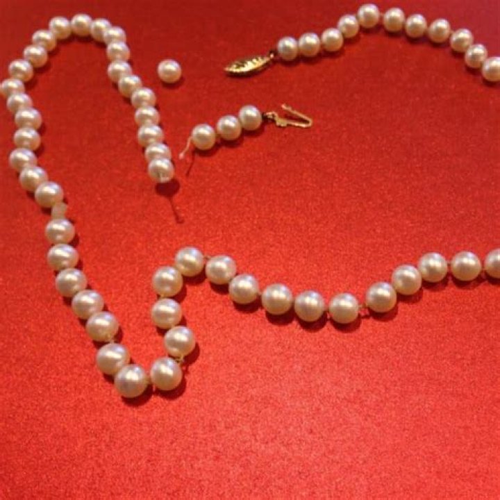 What does Daisy's pearl necklace symbolize?